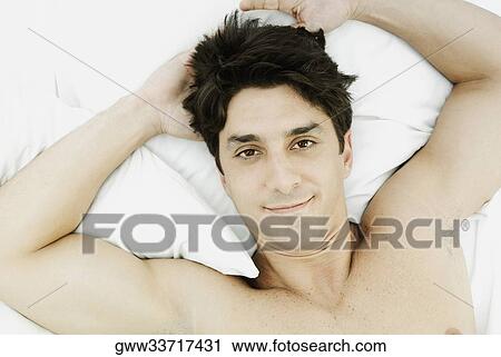 Portrait of a mid adult man lying on the bed View Large Photo Image Stock Image - Portrait of a mid adult man lying on the bed. Fotosearch