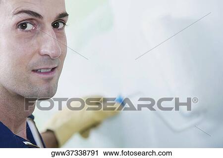Portrait of a mid adult man painting a wall with a paint roller View Large Photo Image Stock Image - Portrait of a mid adult man painting a wall with a paint roller. Fotosearch