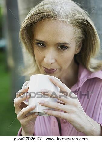 Portrait of a mid adult woman drinking tea View Large Photo Image Stock Image - Portrait of a mid adult woman drinking tea. Fotosearch