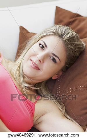 Portrait of a mid adult woman lying on a couch View Large Photo Image Stock Image - Portrait of a mid adult woman lying on a couch. Fotosearch