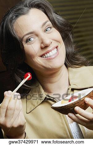 Portrait of a mid adult woman showing a cherry View Large Photo Image Stock Image - Portrait of a mid adult woman showing a cherry. Fotosearch