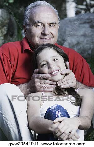 Stock Image - Portrait of a senior man and his granddaughter smiling. Fotosearch