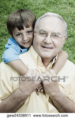 Portrait of a senior man giving a piggyback to his grandson and smiling View Large Photo Image Stock Image - Portrait of a senior man giving a piggyback to his grandson and smiling. Fotosearch