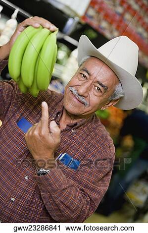 Portrait of a senior man holding a bunch of bananas View Large Photo Image Stock Image - Portrait of a senior man holding a bunch of bananas. Fotosearch