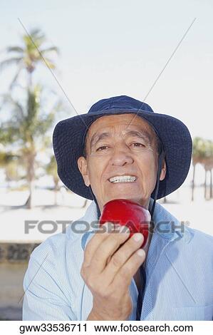 Portrait of a senior man holding an apple and smiling View Large Photo Image Stock Image - Portrait of a senior man holding an apple and smiling. Fotosearch