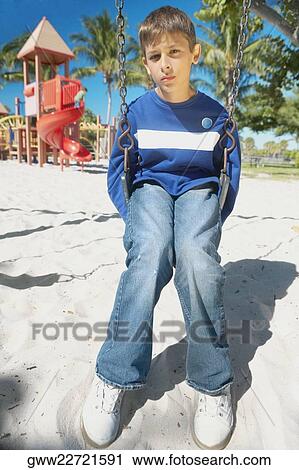 Portrait of a teenage boy sitting on a swing View Large Photo Image Stock Image - Portrait of a teenage boy sitting on a swing. Fotosearch