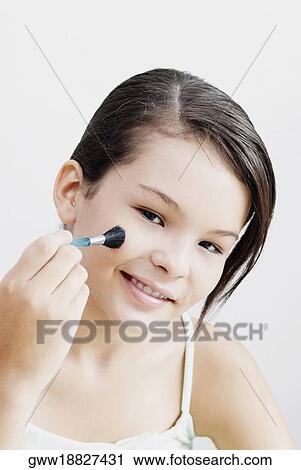 Portrait of a teenage girl applying blush on her cheeks View Large Photo Image Stock Image - Portrait of a teenage girl applying blush on her cheeks. Fotosearch