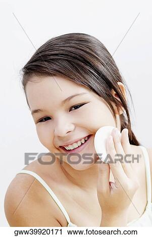 Portrait of a teenage girl applying face powder on her cheeks View Large Photo Image Stock Image - Portrait of a teenage girl applying face powder on her cheeks. Fotosearch