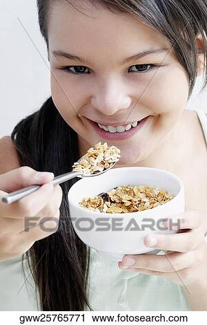Portrait of a teenage girl eating a bowl of corn flakes View Large Photo Image Stock Image - Portrait of a teenage girl eating a bowl of corn flakes. Fotosearch