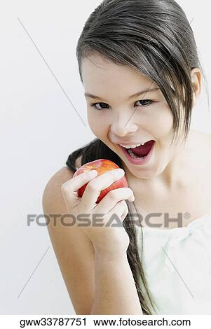 Portrait of a teenage girl eating an apple View Large Photo Image Stock Image - Portrait of a teenage girl eating an apple. Fotosearch