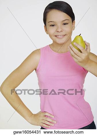 Portrait of a teenage girl holding a pear View Large Photo Image Stock Image - Portrait of a teenage girl holding a pear. Fotosearch