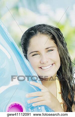 Portrait of a teenage girl holding a pool raft and smiling View Large Photo Image Stock Image - Portrait of a teenage girl holding a pool raft and smiling. Fotosearch