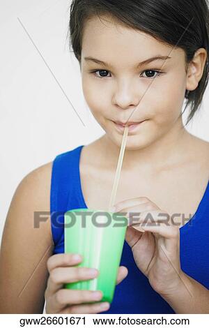Stock Image - Portrait of a teenage girl sipping a drink. Fotosearch