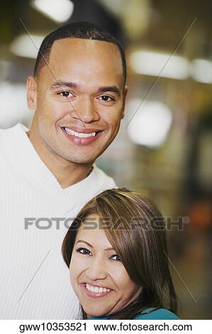 Stock Image - Portrait of a young couple smiling. Fotosearch