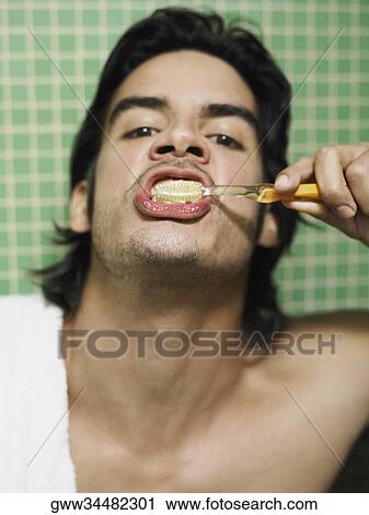 Portrait of a young man brushing his teeth View Large Photo Image Stock Image - Portrait of a young man brushing his teeth. Fotosearch