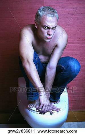 Portrait of a young man crouching on a toilet bowl View Large Photo Image Stock Image - Portrait of a young man crouching on a toilet bowl. Fotosearch