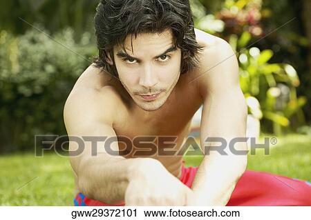 Portrait of a young man exercising in a garden View Large Photo Image Stock Image - Portrait of a young man exercising in a garden. Fotosearch