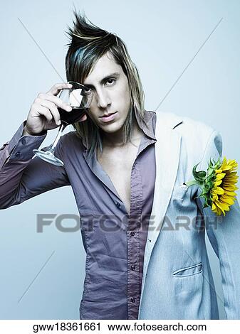 Portrait of a young man holding a glass of red wine over his eye View Large Photo Image Stock Image - Portrait of a young man holding a glass of red wine over his eye. Fotosearch