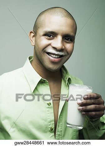 Portrait of a young man holding a glass of milk View Large Photo Image Stock Image - Portrait of a young man holding a glass of milk. Fotosearch