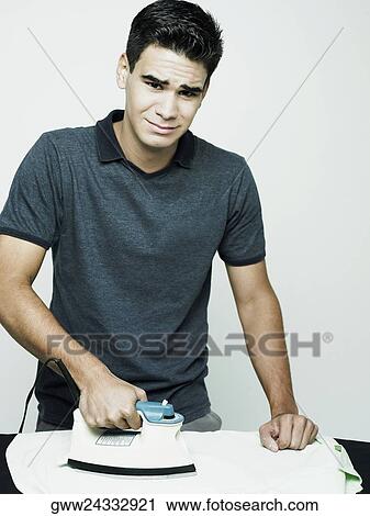 Portrait of a young man ironing a shirt View Large Photo Image Stock Image - Portrait of a young man ironing a shirt. Fotosearch