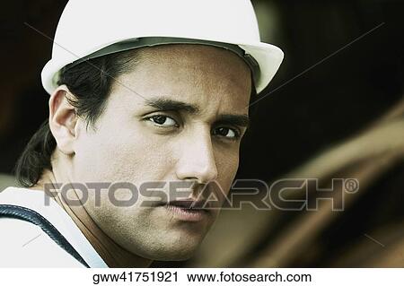 Stock Image - Portrait of a young man looking serious. Fotosearch