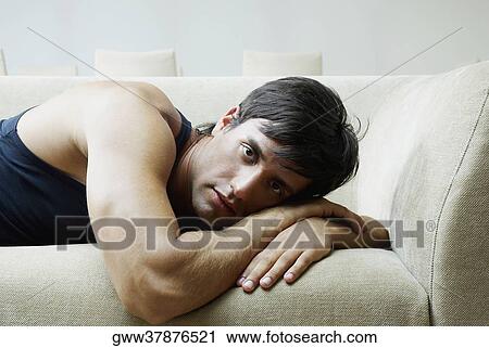 Portrait of a young man lying on a couch View Large Photo Image Stock Image - Portrait of a young man lying on a couch. Fotosearch