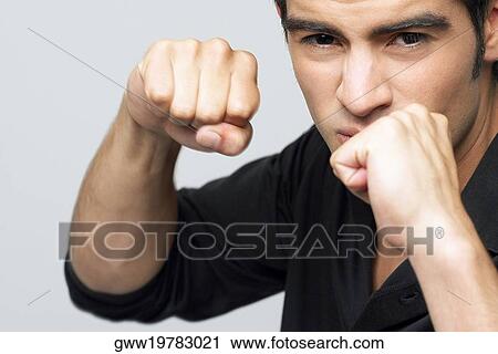Stock Image - Portrait of a young man making a fist. Fotosearch