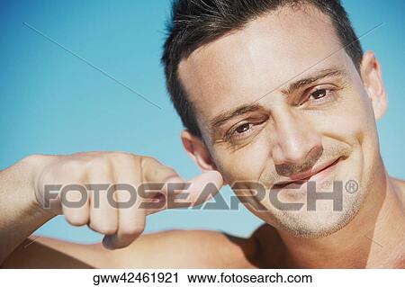 Portrait of a young man pointing forward View Large Photo Image Stock Image - Portrait of a young man pointing forward. Fotosearch