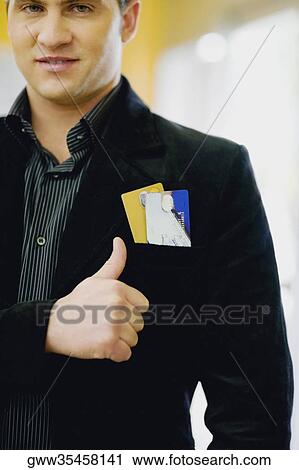 Stock Image - Portrait of a young man smiling and making a thumbs up sign. Fotosearch