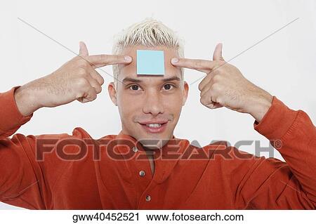 Portrait of a young man smiling with an adhesive note on his forehead View Large Photo Image Stock Image - Portrait of a young man smiling with an adhesive note on his forehead. Fotosearch