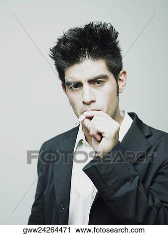 Portrait of a young man smoking a cigarette View Large Photo Image Stock Image - Portrait of a young man smoking a cigarette. Fotosearch