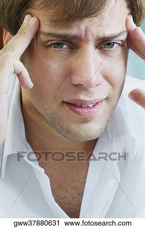Portrait of a young man suffering from a headache View Large Photo Image Stock Image - Portrait of a young man suffering from a headache. Fotosearch