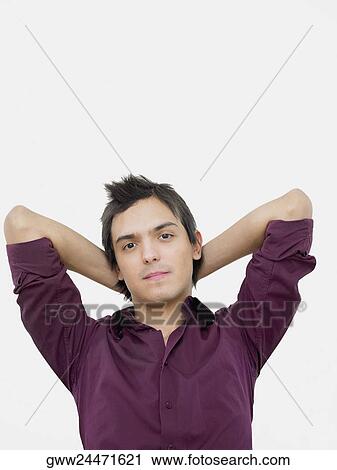 Portrait of a young man with his hands behind his head View Large Photo Image Stock Image - Portrait of a young man with his hands behind his head. Fotosearch