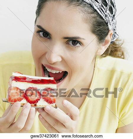 Portrait of a young woman eating a slice of strawberry cake View Large Photo Image Stock Image - Portrait of a young woman eating a slice of strawberry cake. Fotosearch