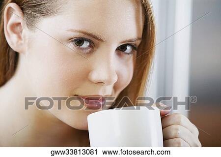 Portrait of a young woman holding a cup of tea View Large Photo Image Stock Image - Portrait of a young woman holding a cup of tea. Fotosearch