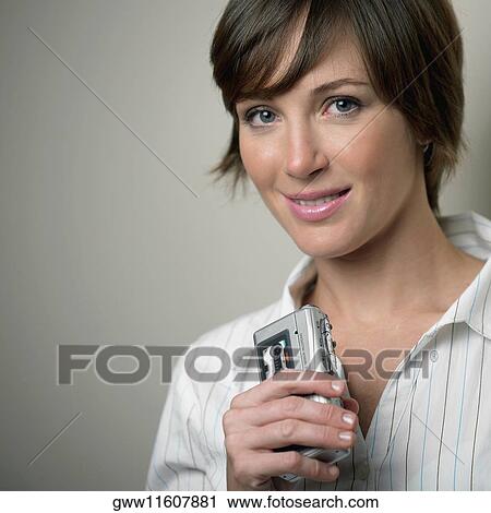 Stock Image - Portrait of a young woman holding a tape recorder. Fotosearch