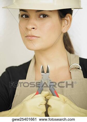 Portrait of a young woman holding a pair of pliers View Large Photo Image Stock Image - Portrait of a young woman holding a pair of pliers. Fotosearch