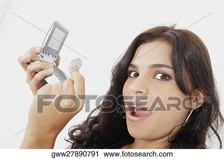 Portrait of a young woman holding a calculator and a coin View Large Photo Image Stock Image - Portrait of a young woman holding a calculator and a coin. Fotosearch