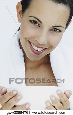 Portrait of a young woman holding a bowl and smiling View Large Photo Image Stock Image - Portrait of a young woman holding a bowl and smiling. Fotosearch