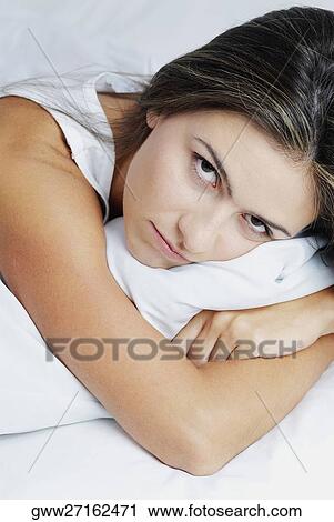 Portrait of a young woman hugging a pillow View Large Photo Image Stock Image - Portrait of a young woman hugging a pillow. Fotosearch