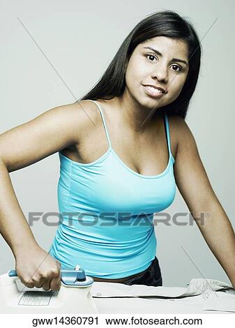 Portrait of a young woman ironing a shirt and smiling View Large Photo Image Stock Image - Portrait of a young woman ironing a shirt and smiling. Fotosearch