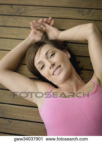 Portrait of a young woman lying on a hardwood floor and smiling View Large Photo Image Stock Image - Portrait of a young woman lying on a hardwood floor and smiling. Fotosearch