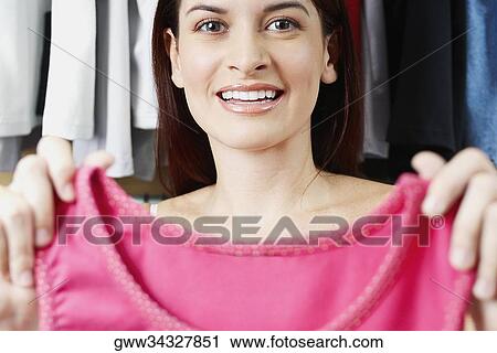 Stock Image - Portrait of a young woman showing a top. Fotosearch