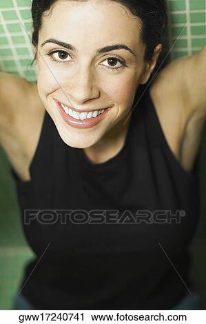 Portrait of a young woman smiling with her arms raised View Large Photo Image Stock Image - Portrait of a young woman smiling with her arms raised. Fotosearch