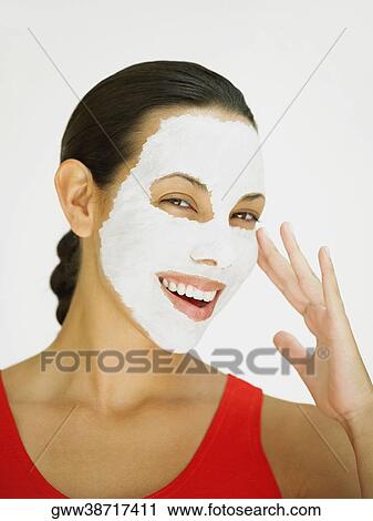 Portrait of a young woman smiling with a facial mask on her face View Large Photo Image Stock Image - Portrait of a young woman smiling with a facial mask on her face. Fotosearch