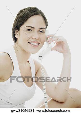 Portrait of a young woman using a telephone View Large Photo Image Stock Image - Portrait of a young woman using a telephone. Fotosearch