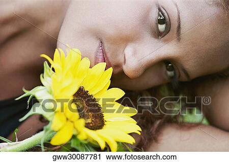 Portrait of a young woman with a sunflower View Large Photo Image Stock Image - Portrait of a young woman with a sunflower. Fotosearch