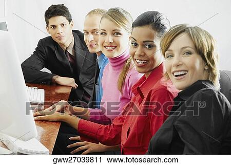 Stock Image - Portrait of business executives sitting in front of a computer. Fotosearch