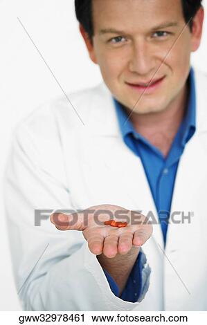 Portrait of male doctor holding pill on his palm View Large Photo Image Stock Image - Portrait of male doctor holding pill on his palm. Fotosearch