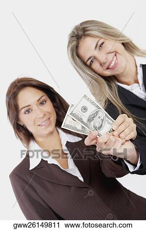 Portrait of two businesswomen holding American paper currency View Large Photo Image Stock Image - Portrait of two businesswomen holding American paper currency. Fotosearch